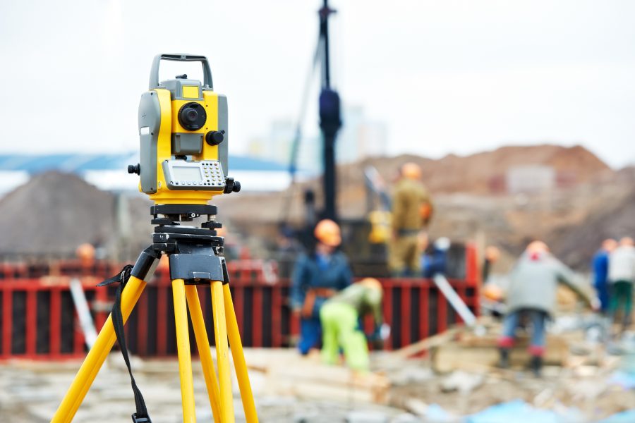 A yellow electronic total station stood on a construction site