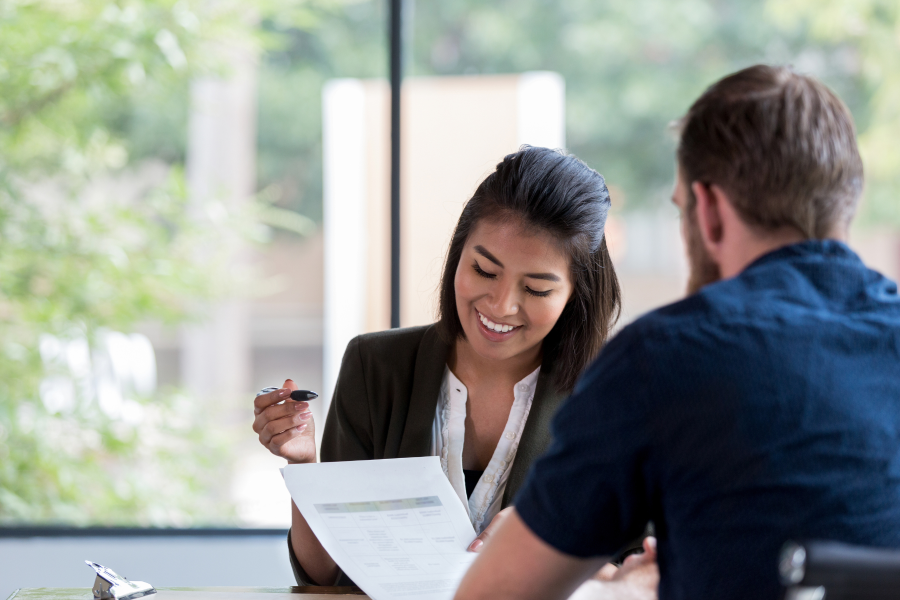 Two professionals sat opposite one another, looking at a piece of paper