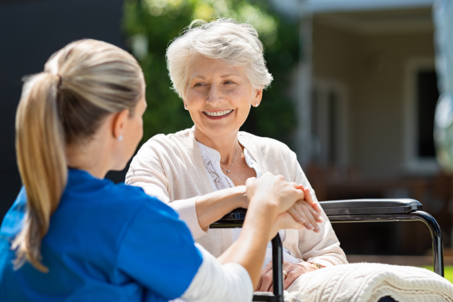 A healthcare working sat conversing with an elderly patient