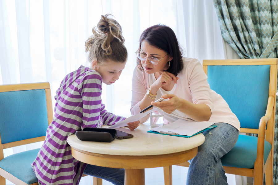A professional and young child sat together, looking at a piece of paper