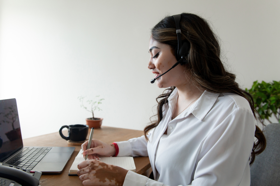 The side profile of a professional who wears a white shirt and microphone headset