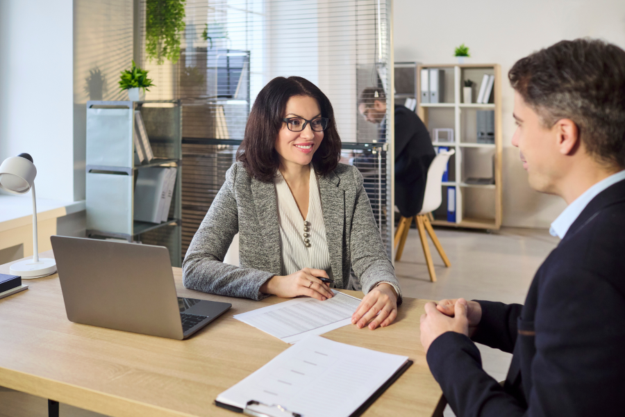 Two smart professionals sat chatting in an office environment