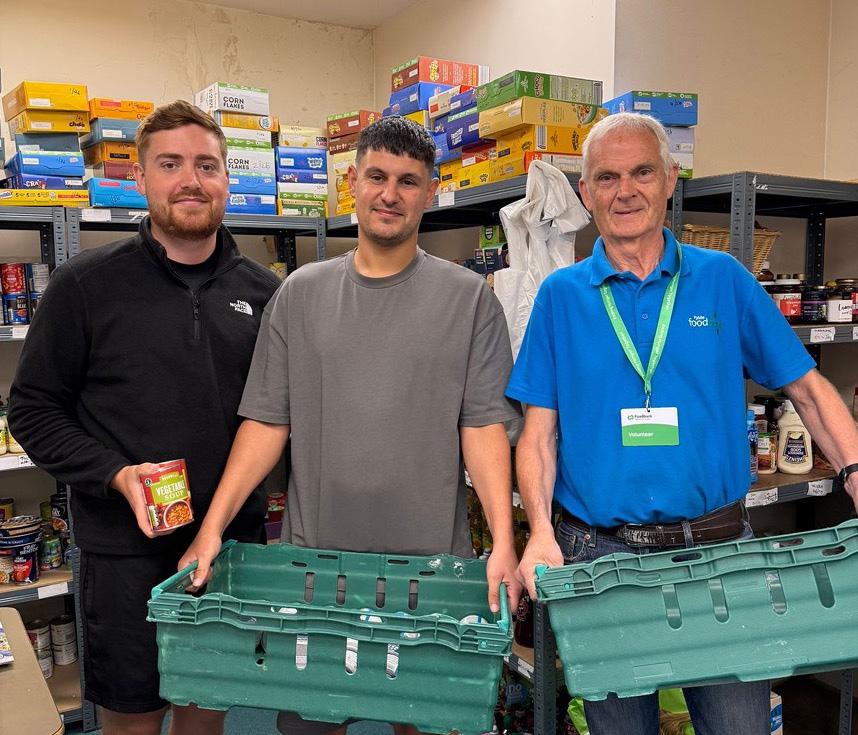 Two Spencer Clarke Group employees and a volunteer at a foodbank