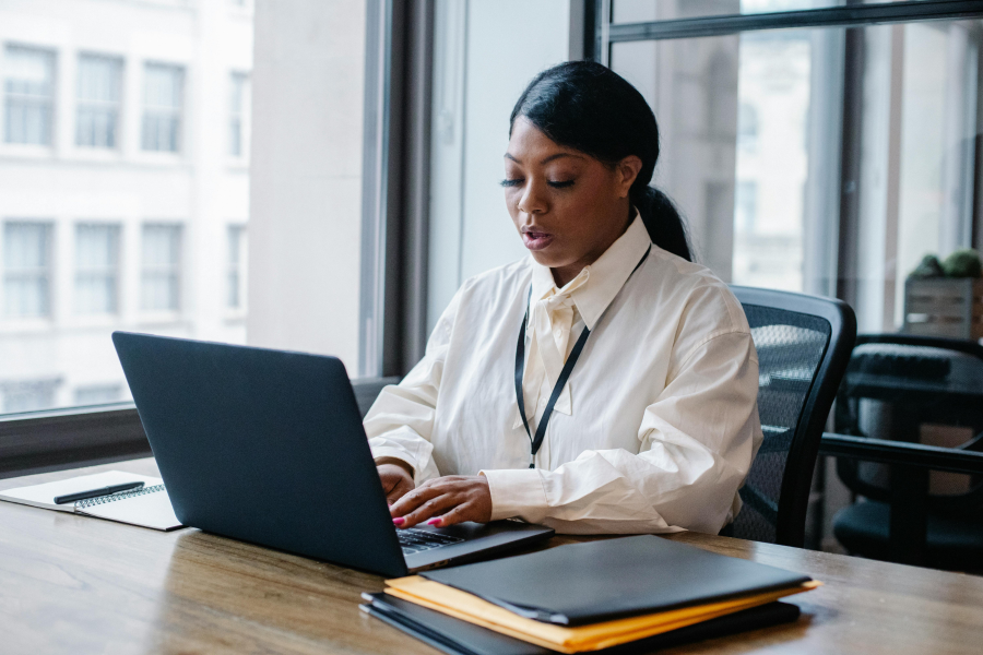 A smart professional typing on their laptop whilst sat at a desk
