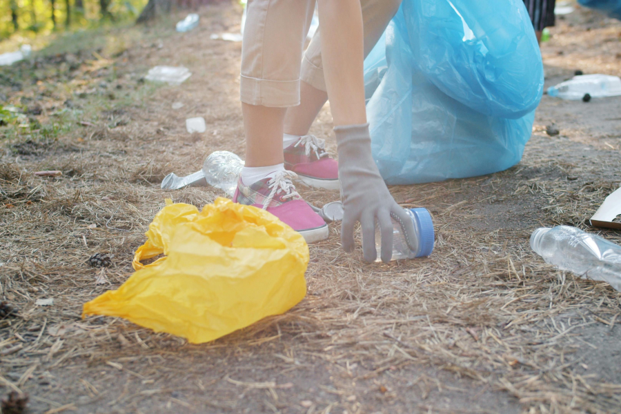The hand of a person picking up plastic litter