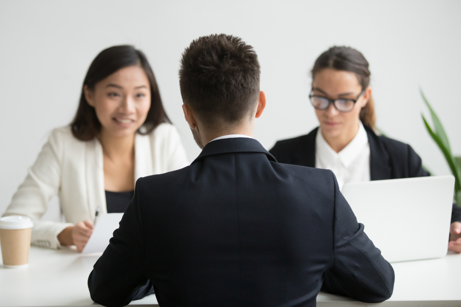 Three professionals sat speaking across a desk