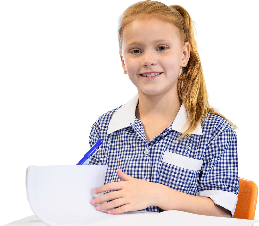 A school girl sat at a desk holding a pen and paper
