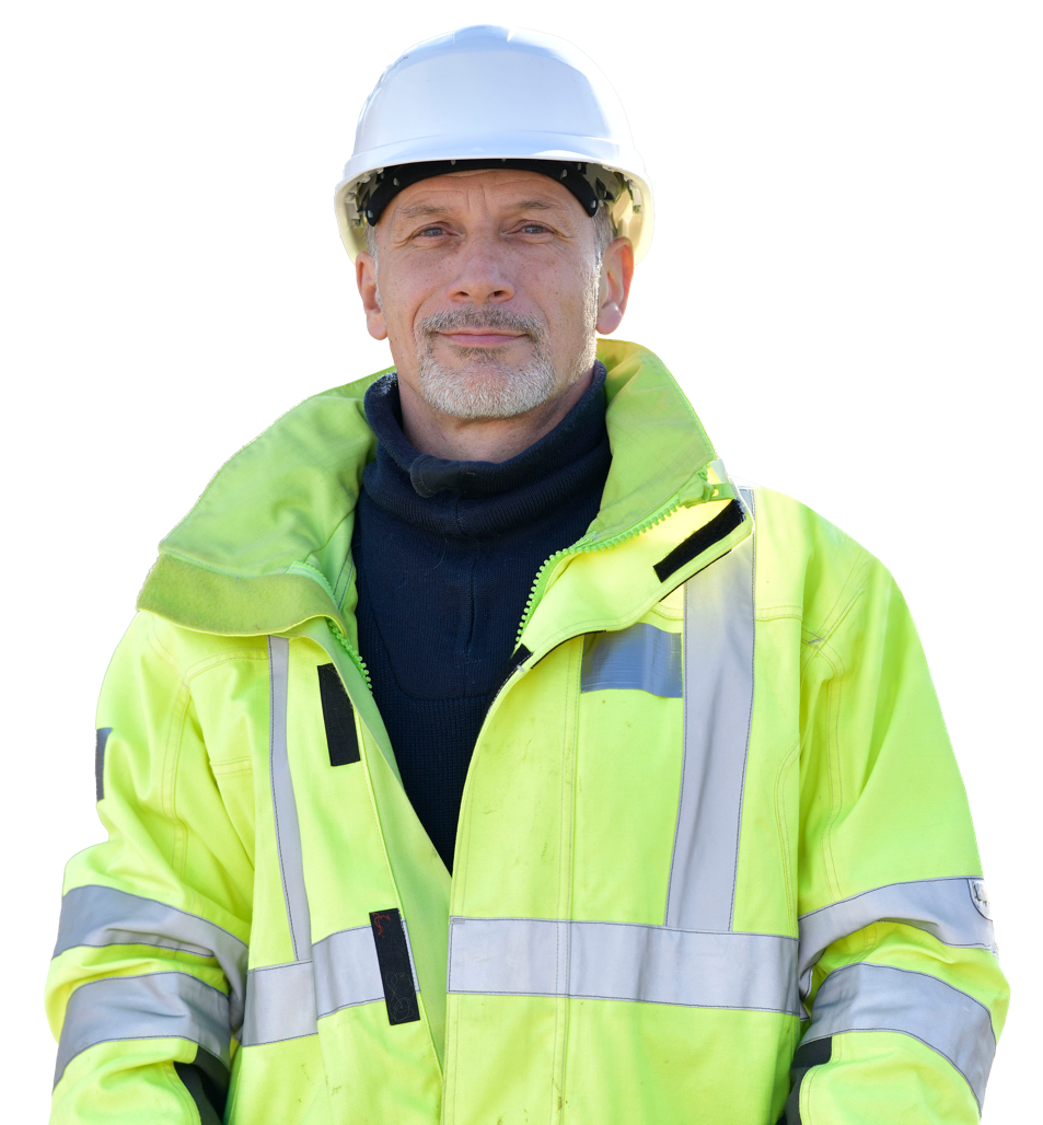 A construction worker wearing a green high vis jacket and white hard hat