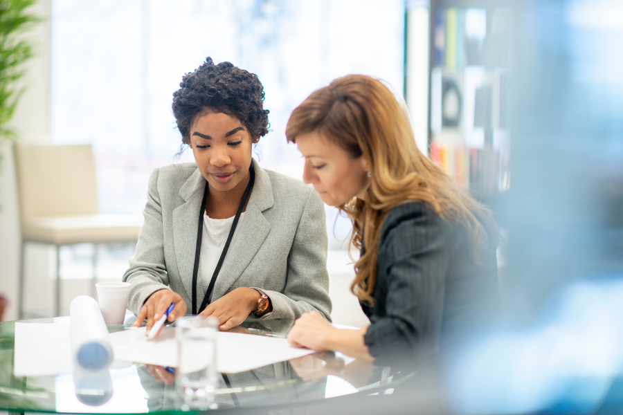 Two professionals sitting and looking at a piece of paper
