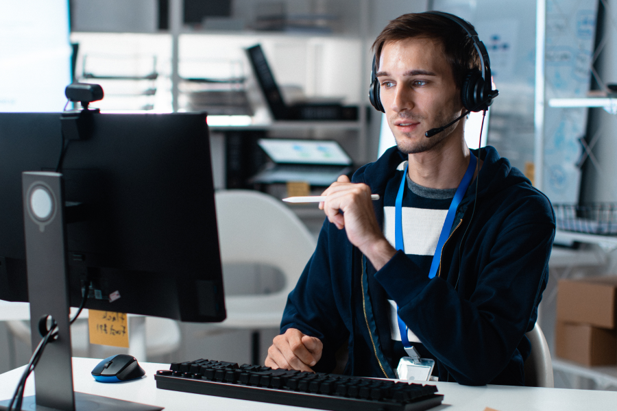 A professional sat at their desk wearing a microphoned headset