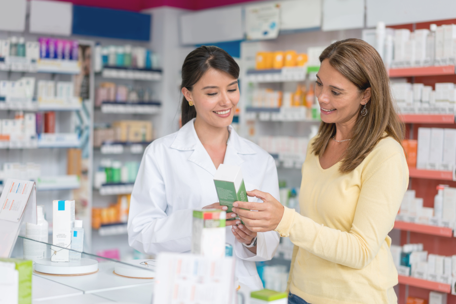 A Pharmacist showing a customer a box of medication