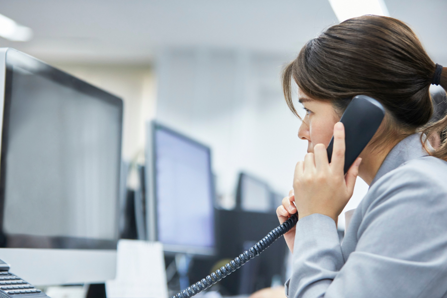 The side profile of a professional speaking into a telephone
