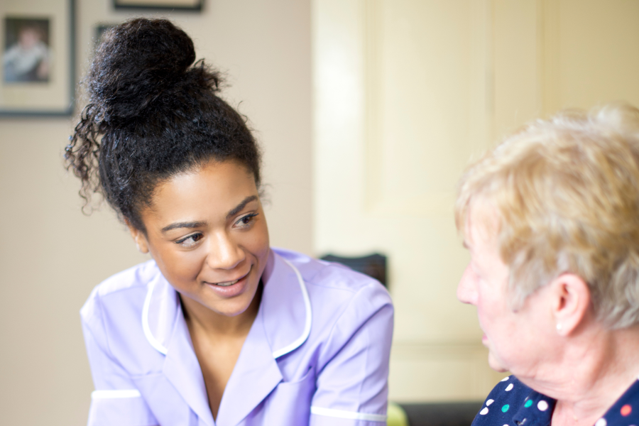 A healthcare professional smiling at an elderly person