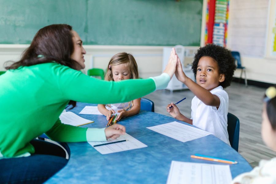 A professional giving a young school child a high five