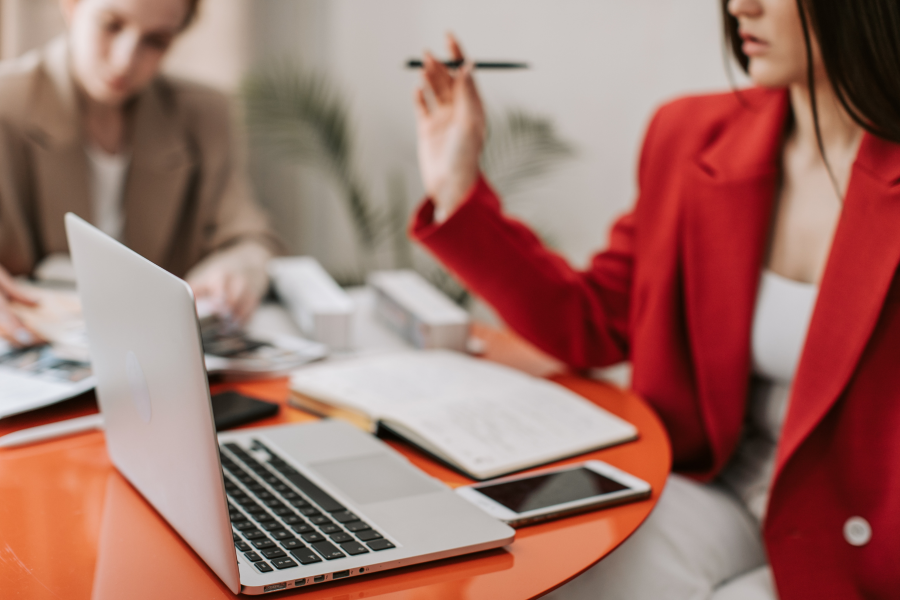 Two professionals sat at a red table working