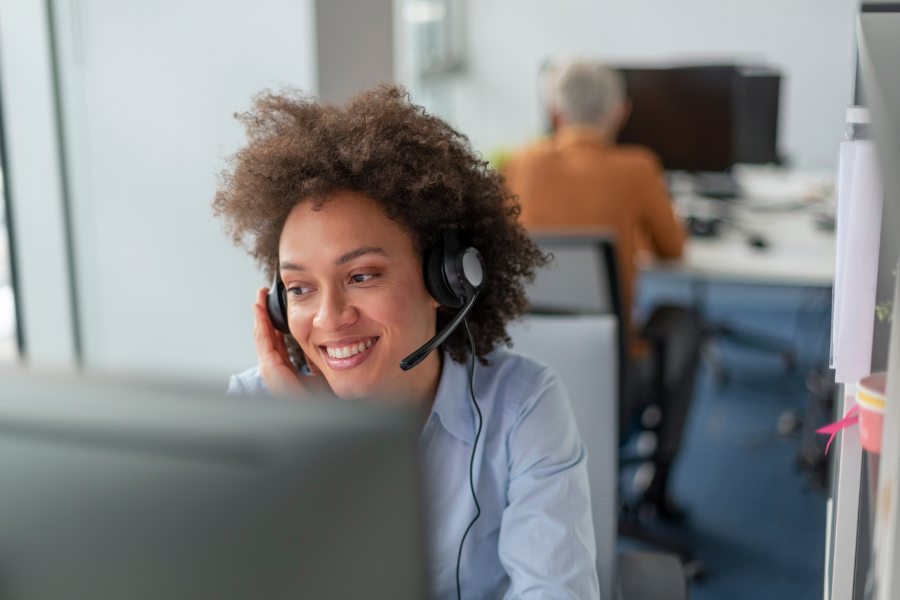 A professional wearing a microphone headset, smiling