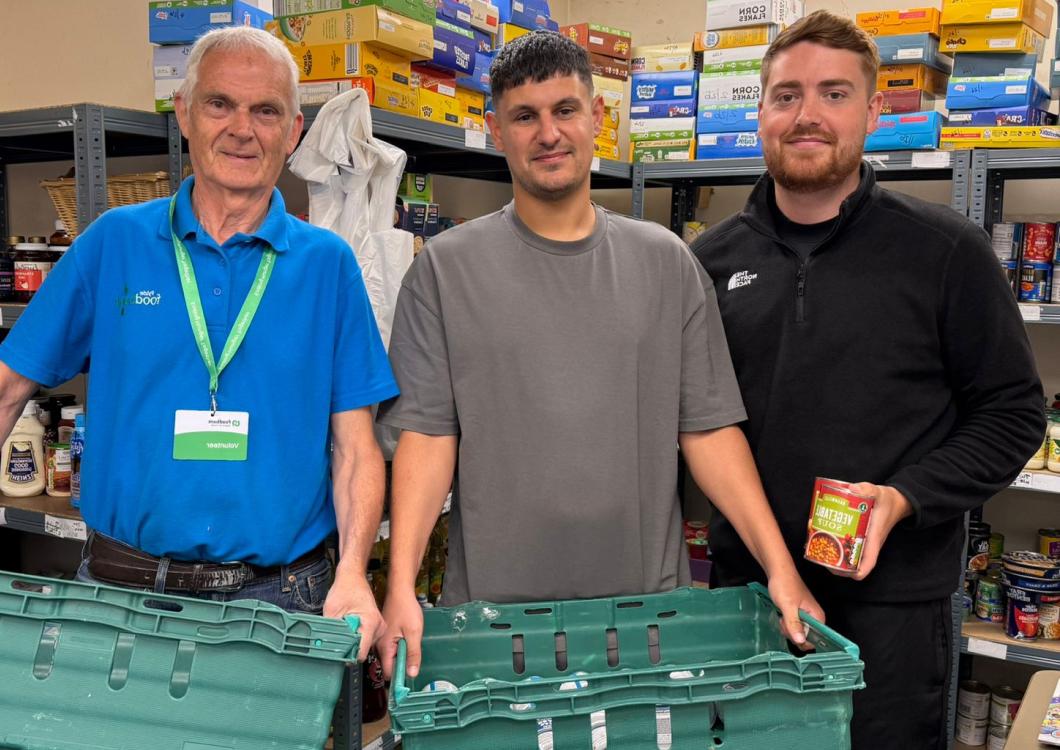 Two Spencer Clarke Group employees and a volunteer at a foodbank