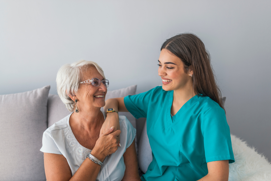A healthcare professional smiling at an elderly patient
