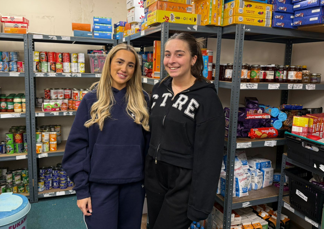 Two Spencer Clarke Group employees volunteering at a foodbank