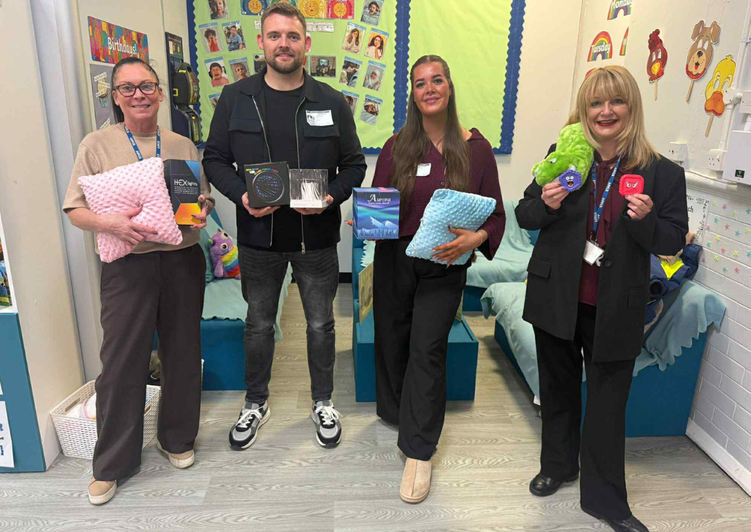 Two Spencer Clarke Group employees and two teaching professionals holding sensory toys