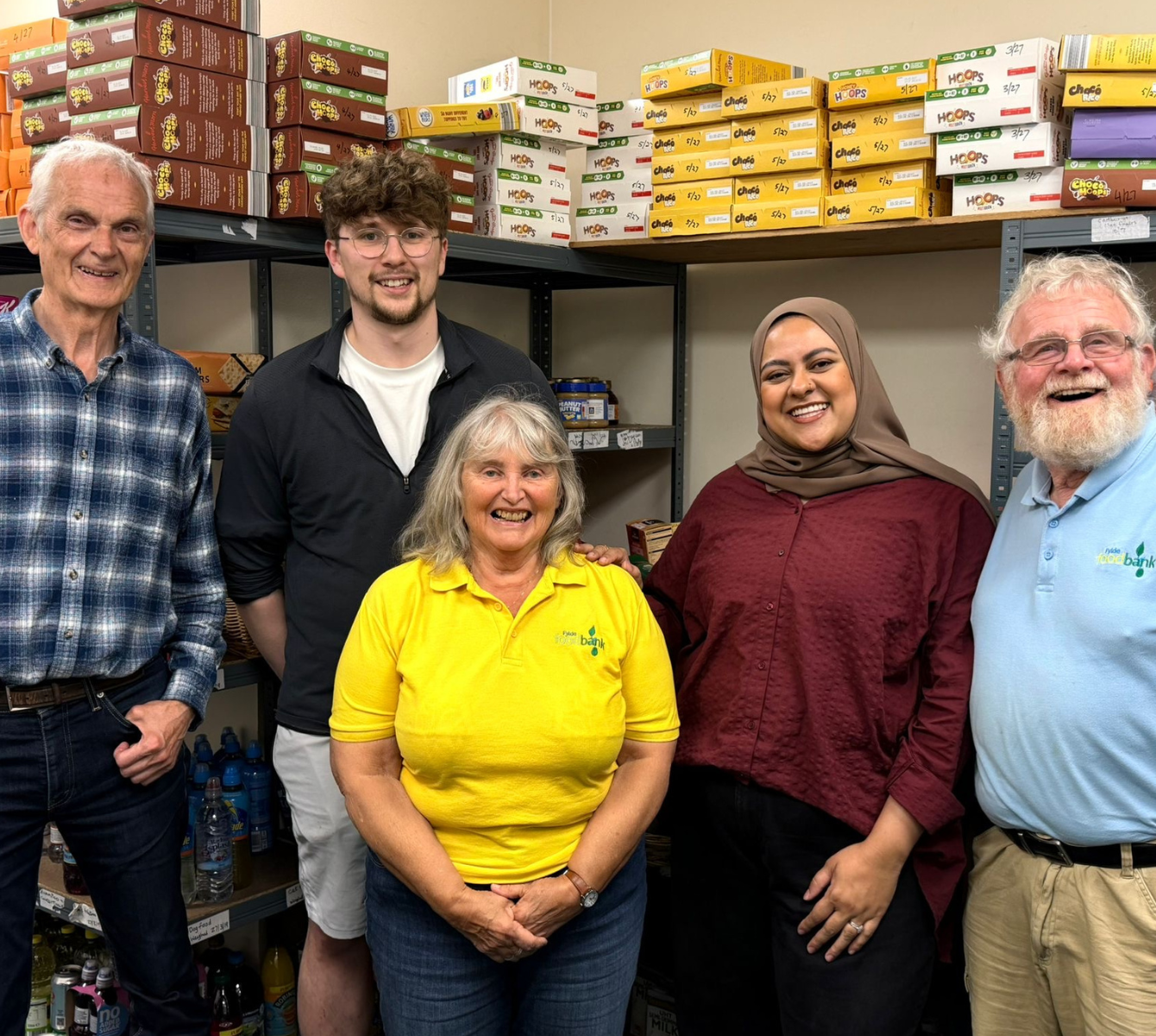 Two Spencer Clarke Group employees and three volunteers at a foodbank