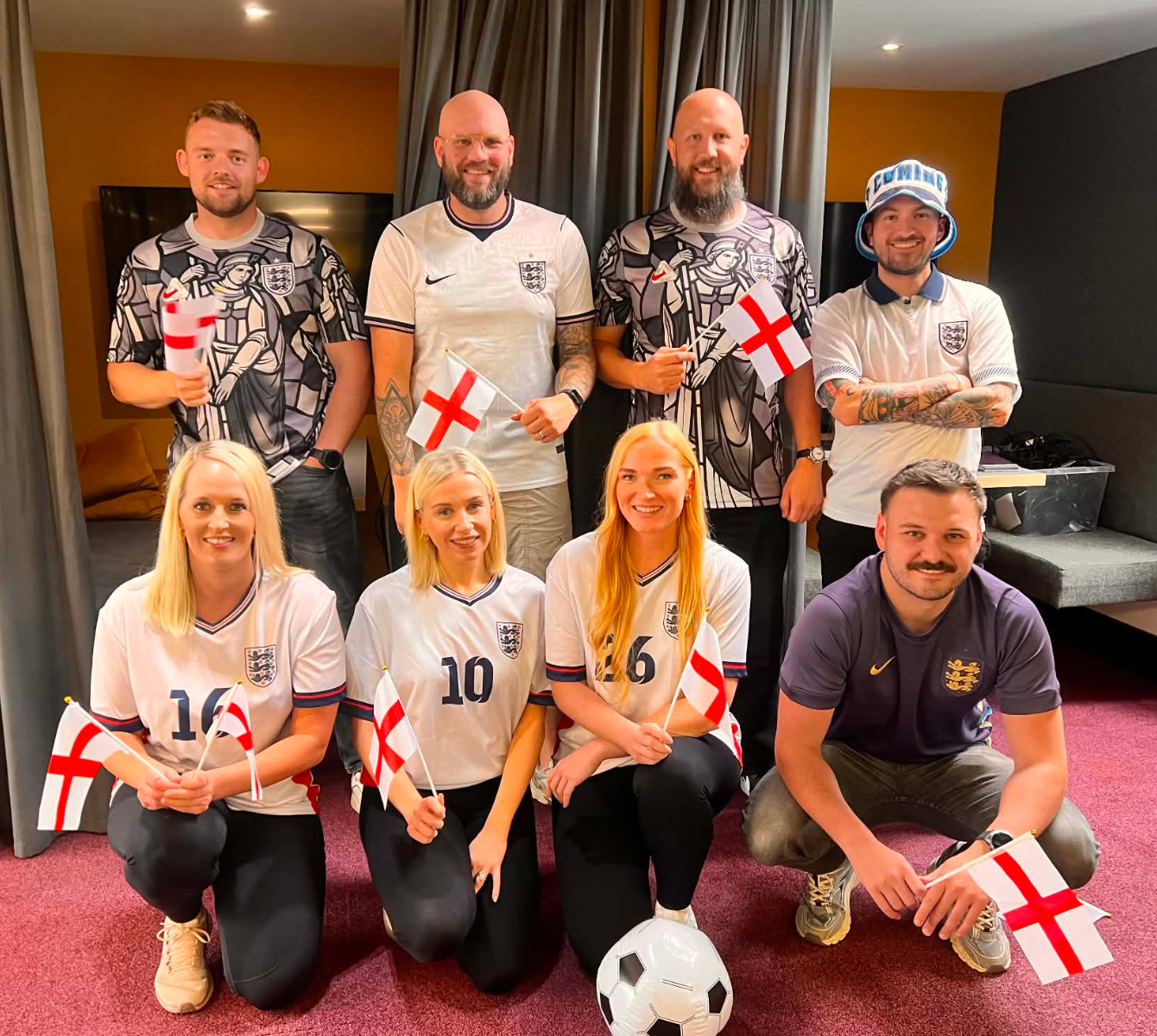 Spencer Clarke Group employees wearing England football shirts and holding flags for the World Cup