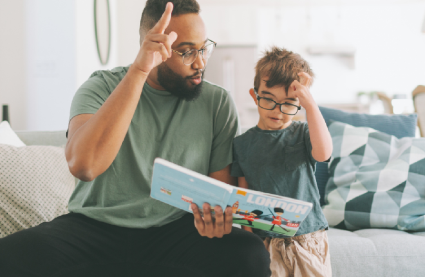An adult reading a book with a young child