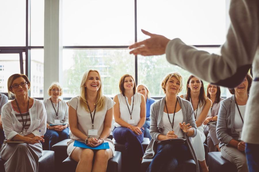 An individual speaking to a group of adults