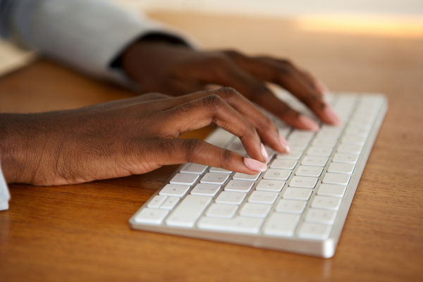 Hands resting on a wireless computer keyboard
